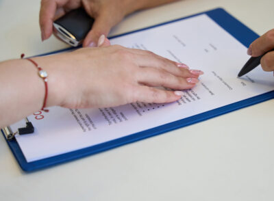 Process of signing documents on the purchase and sale of a car, the manager indicates the place of signature