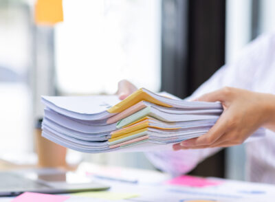 close-up-of-business-hands-working-in-stacks-of-pa-2025-02-22-16-15-29-utc